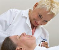 Doctor examining patient's facial skin.